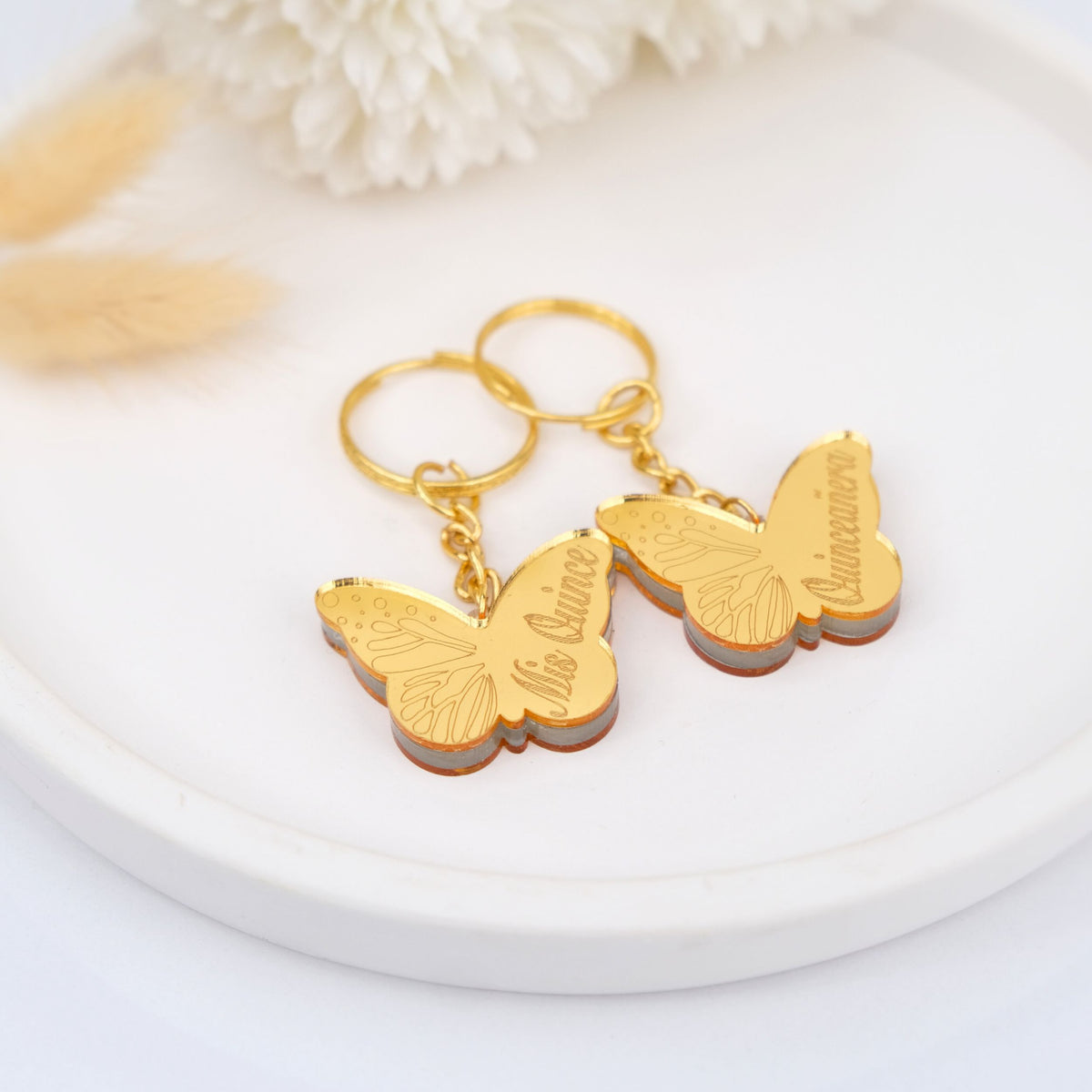 Gold butterfly theme favors on a white surface with a soft focus background