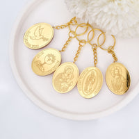 Set of gold keychains with religious designs on a white plate