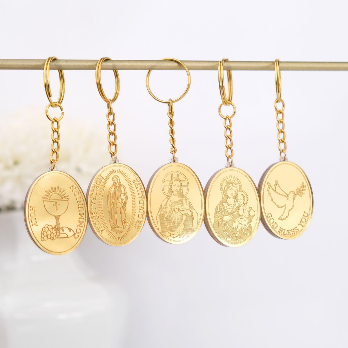 Set of gold religious keychains on a white background