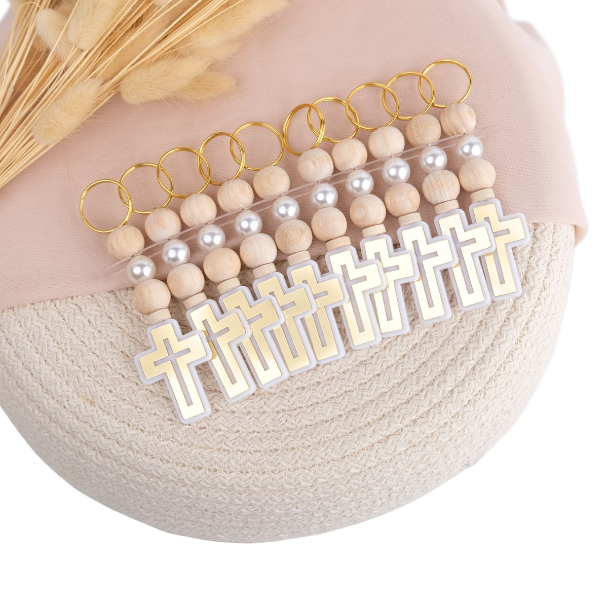 Keychains with wooden beads and cross pendants on a textured surface