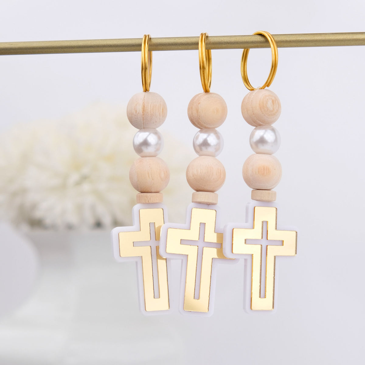 Baptism Keychains with wooden beads and gold cross charms on a white background