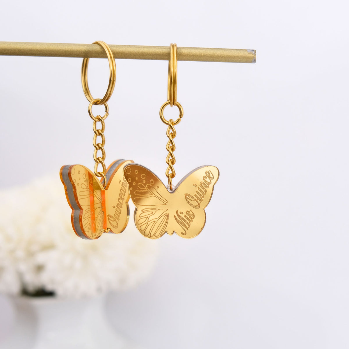 Gold butterfly keychain favors on a white background