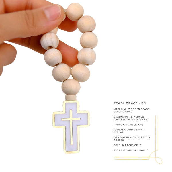 Wooden beaded mini rosary with a white acrylic cross with gold detailed charm held by a hand on a white background.