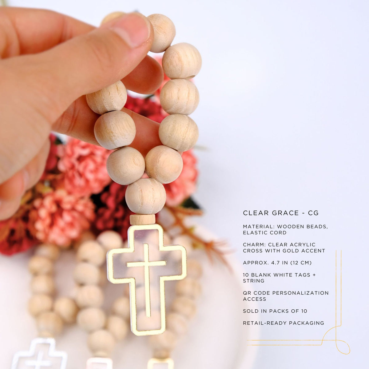 Wooden rosary with clear acrylic cross held by a hand against a floral background