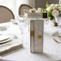 Packaged white baptism candle favor product on a table with a decorative setting