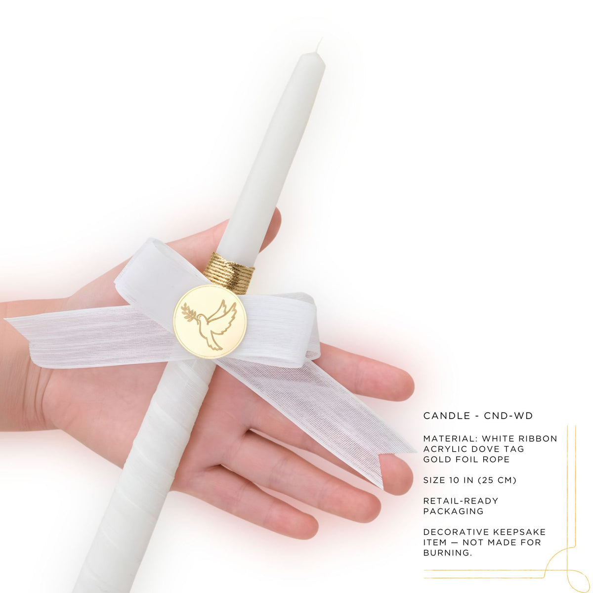 White baptism candle with gold decorative element held by a hand on a white background