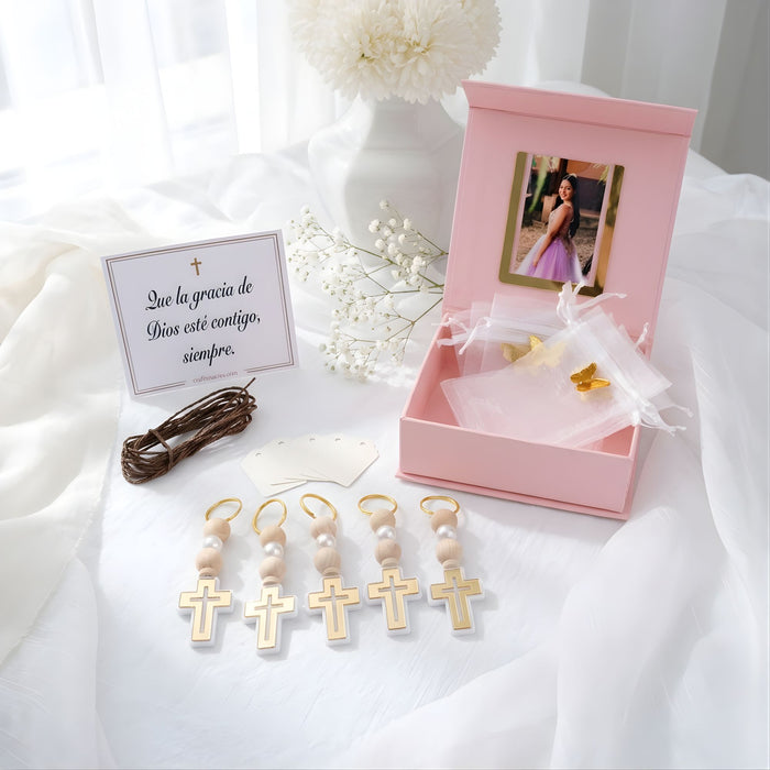 Pink gift box with birthday favors accessories on a white fabric background