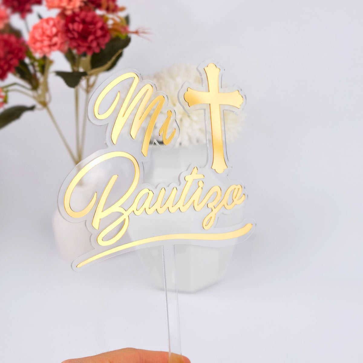 Gold 'Mi Bautizo' cake topper with a cross on a white background