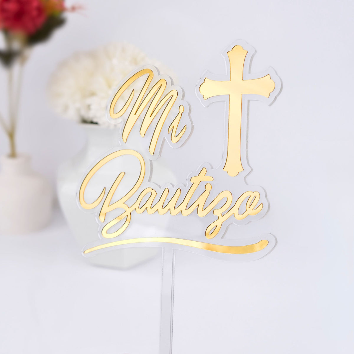 Gold 'Mi Bautizo' cake topper with a cross on a white background