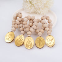 Wooden beaded mini rosaries with gold religious medals on a white background