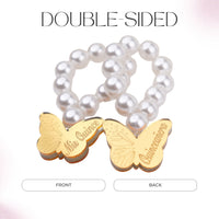 Double-sided pearl mini rosaries with gold butterfly charms on a white background