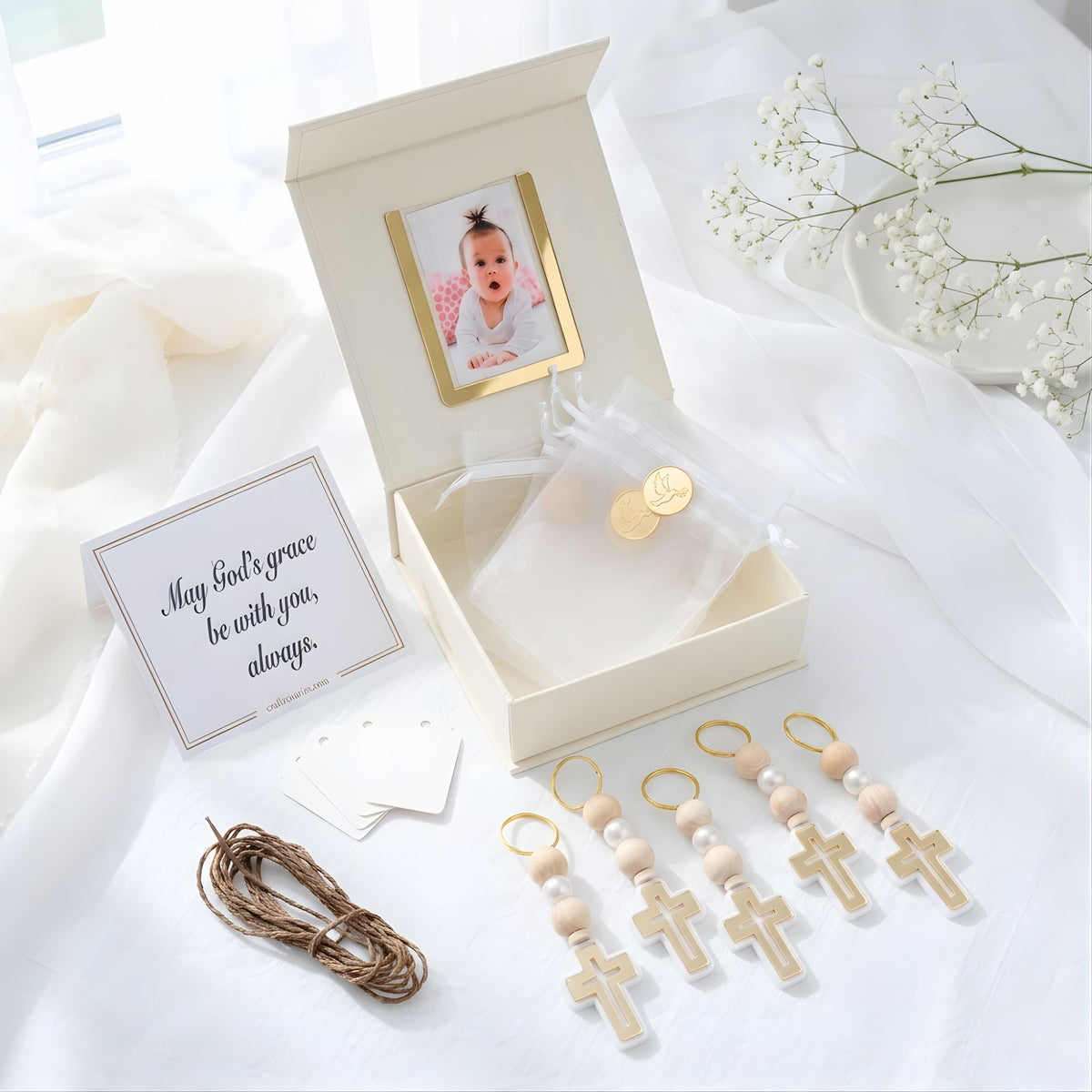 Baby shower gift set with pacifier clip, photo frame, and card on a white fabric background
