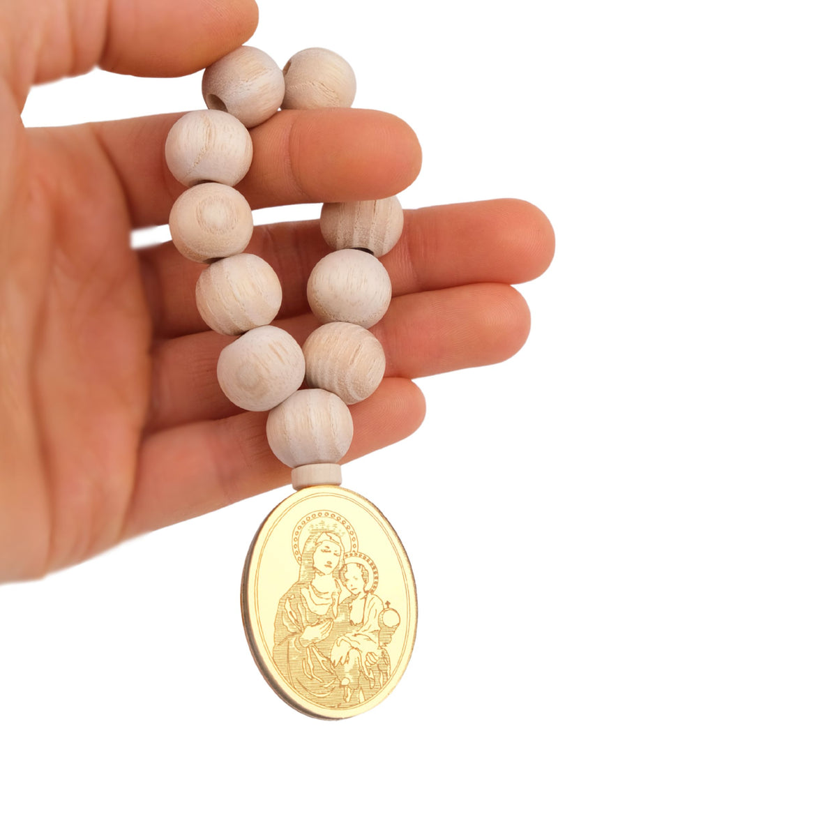 Hand holding a wooden beaded mini rosary with a gold medal featuring an engraved Mother Mary on a white background