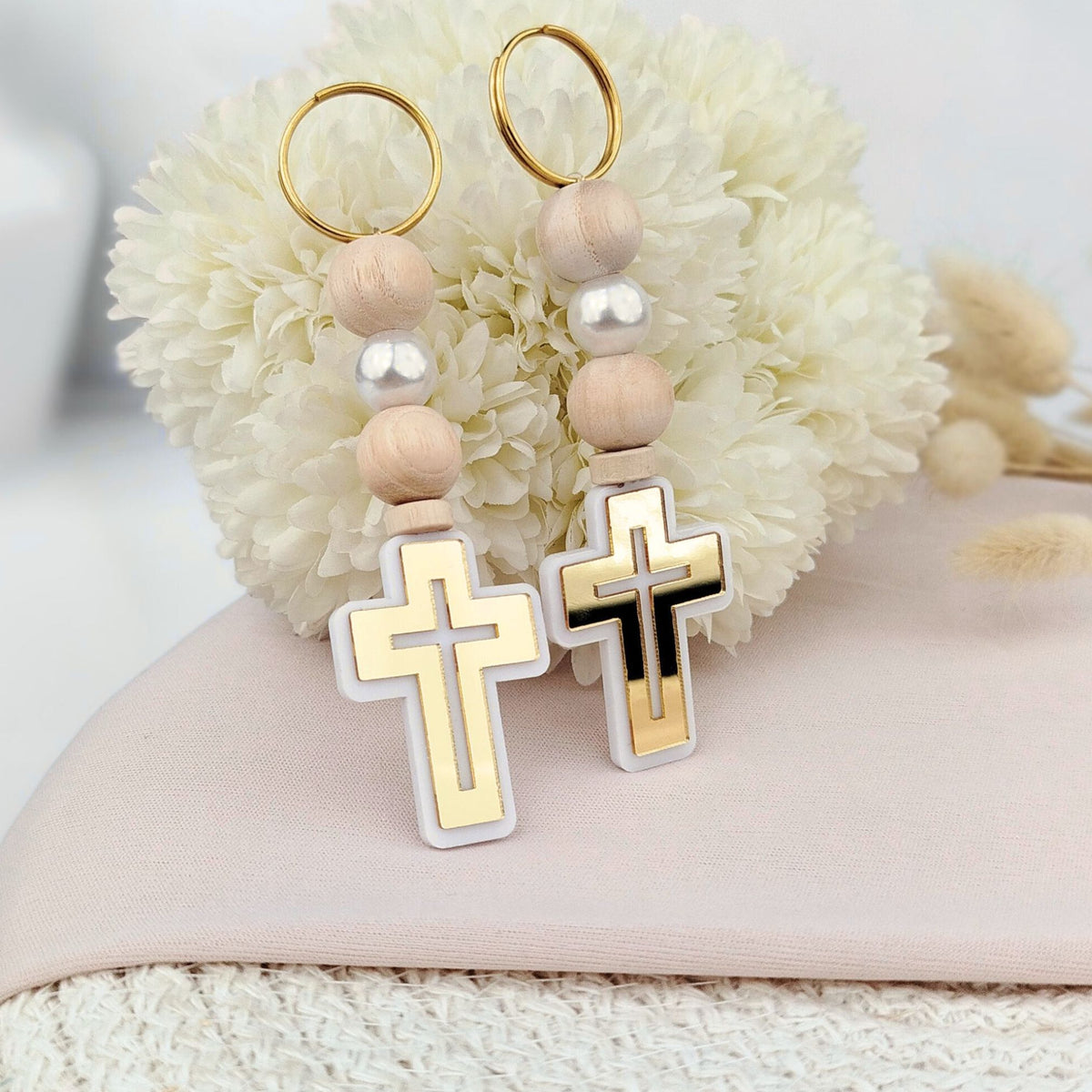 Pair of keychains with cross designs on a white background