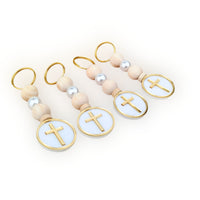 Set of three keychains with wooden beads and gold crosses on a white background