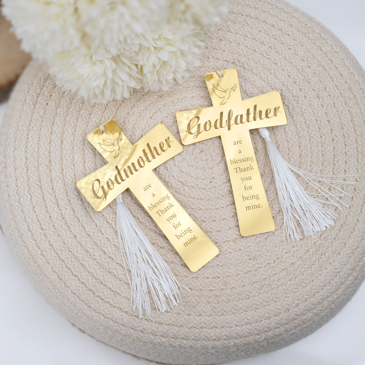Two gold crosses with 'Godmother' and 'Godfather' inscriptions on a textured surface.