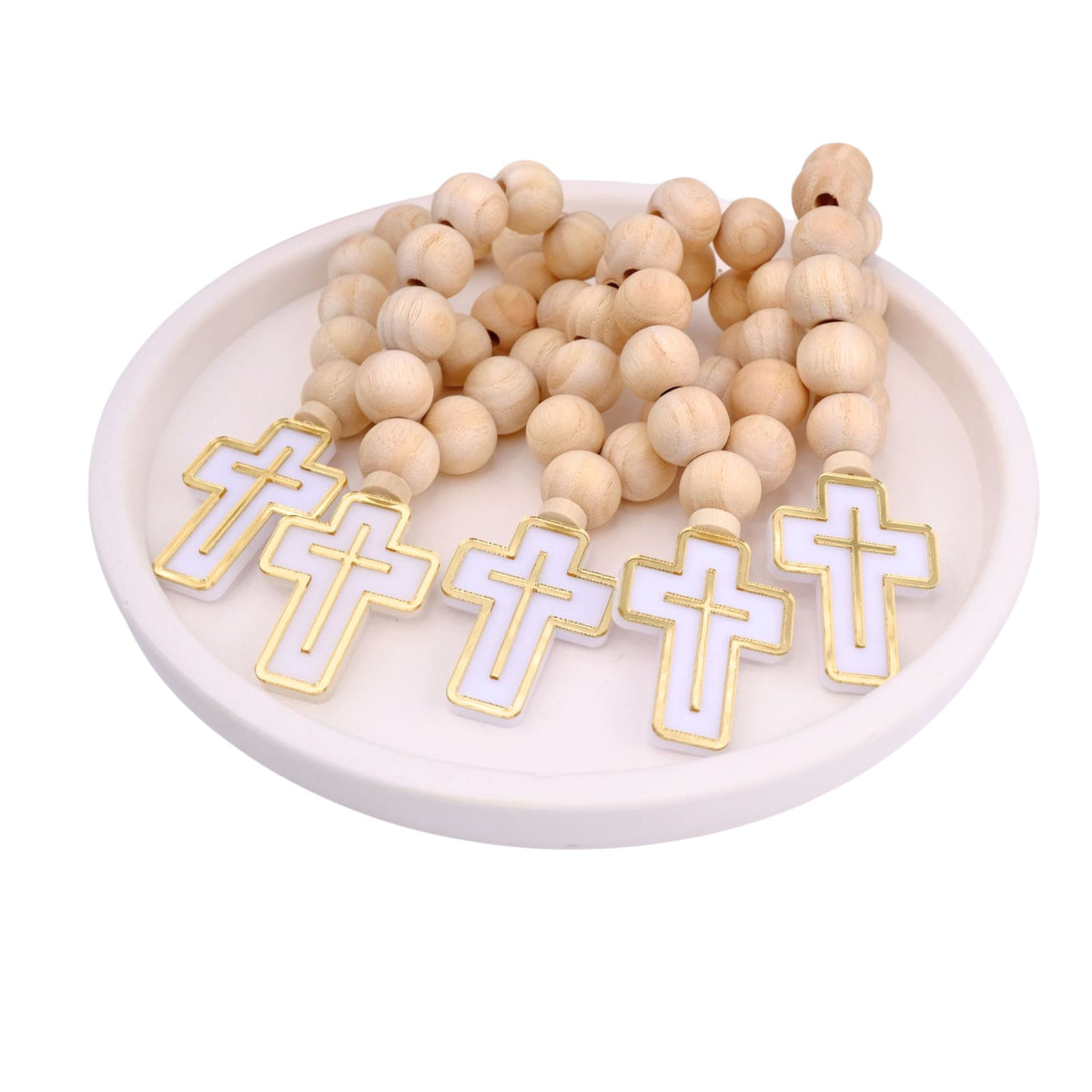 Wooden rosary baptism favors with cross charms on a white dish
