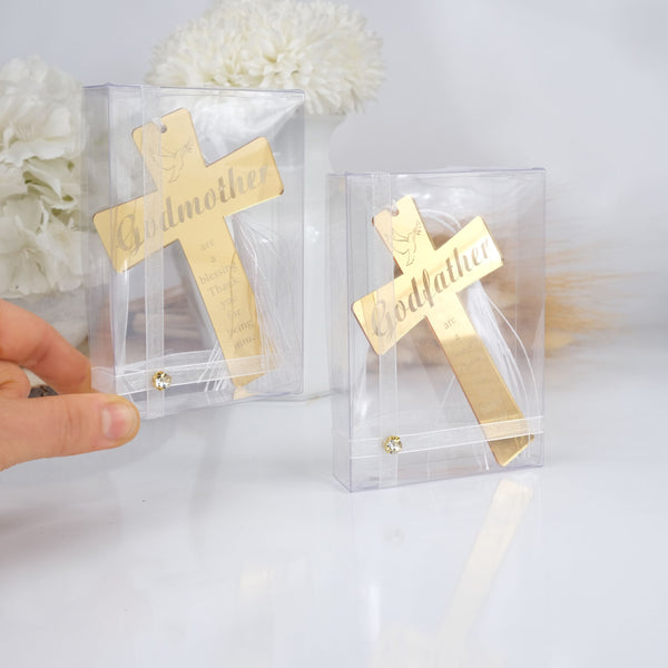 Gold 'Godmother' crosses in clear packaging on a white background