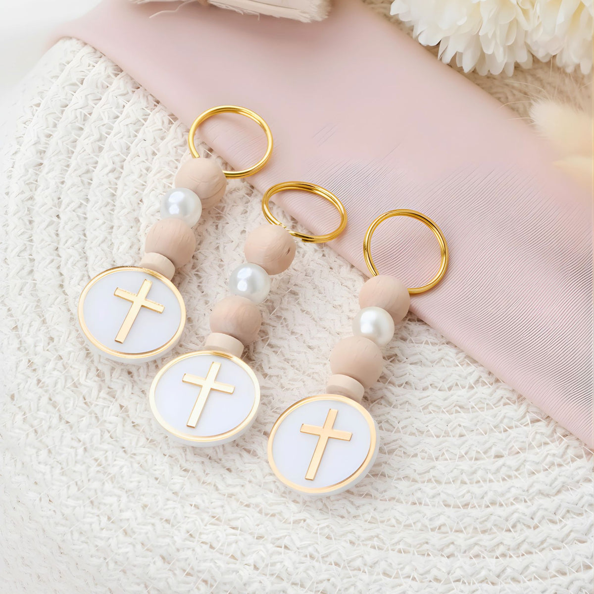 Decorative keychain baptism favor with cross designs on a textured surface
