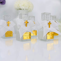 Three small glass holy water bottles with gold crosses and white ribbons on a reflective surface.