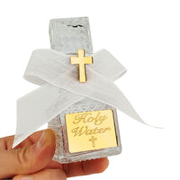 Small glass bottle labeled 'Holy Water' with a gold cross on a white background