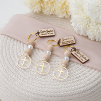 You will love these personalized baptism keychain cross favors. These keychains are crafted with natural wood and pearl beads, and they feature a design with a cross at the end. also customize them with a tag that has the name and date of the baptism