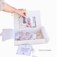 White memory keepsake box with a photo of an elderly woman, wooden crosses, and a card inside.