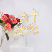 Gold 'Mi Bautizo' cake topper with a cross on a white background