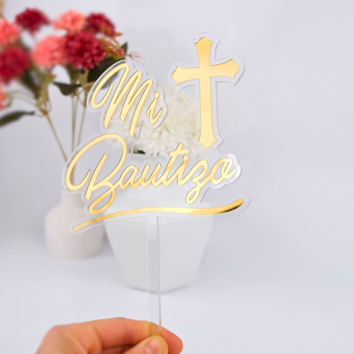 Gold 'Mi Bautizo' cake topper with a cross on a white background