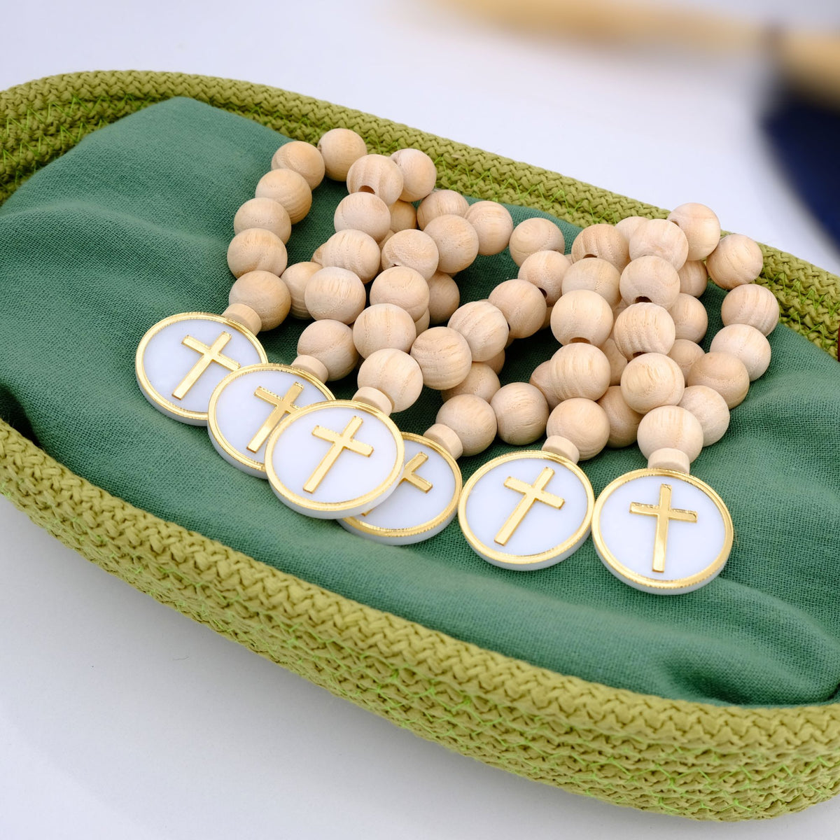 Wooden rosary with cross charms on a green fabric background