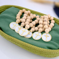 Wooden rosary with cross charms on a green fabric background