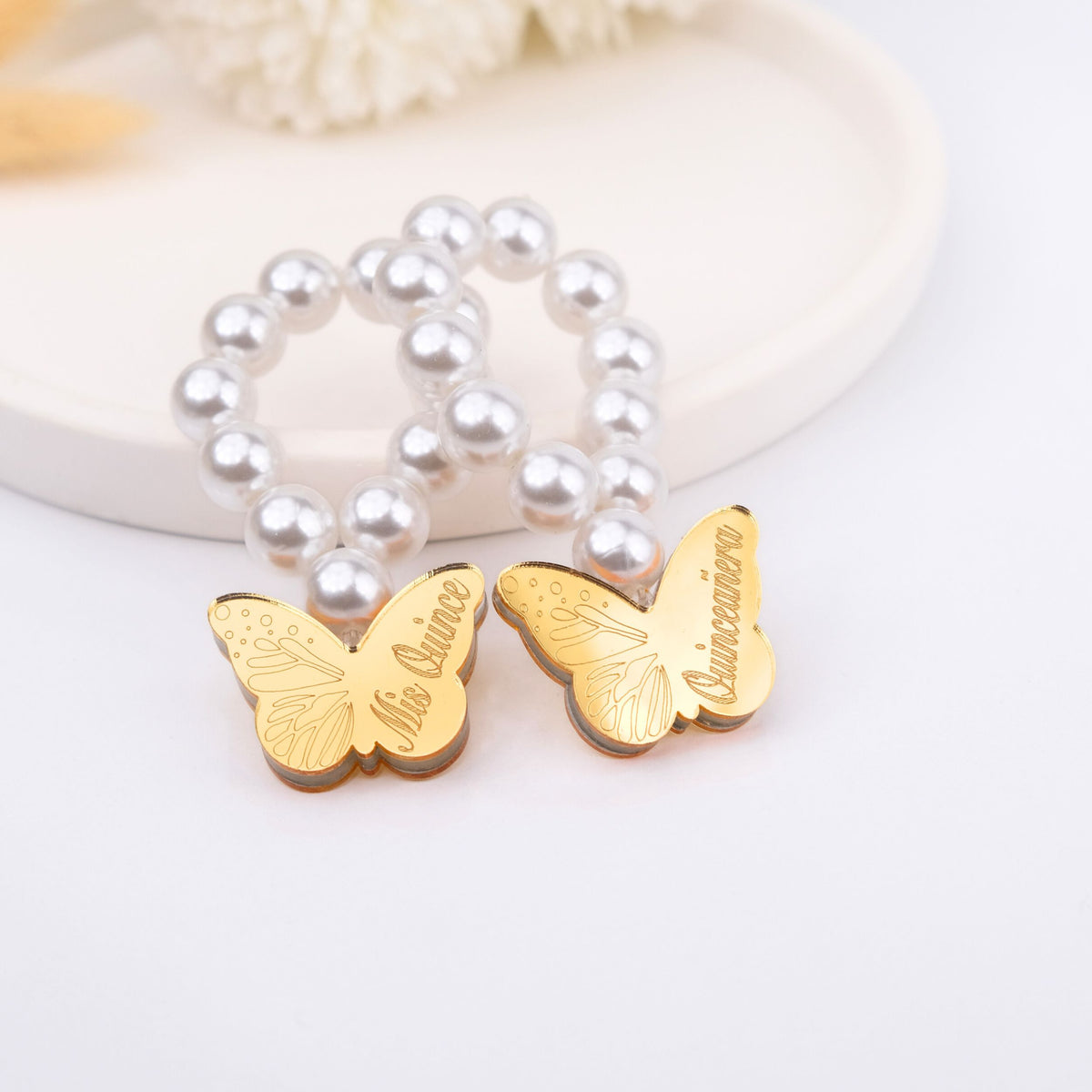 Gold butterfly charms with 'Mis Quince and quinceanera' text on a white background
