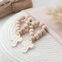 Wooden beaded mini rosary favors with cross pendants on a textured surface