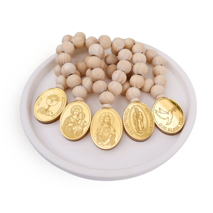 Wooden beaded mini rosary favors with gold religious medallions on a white dish