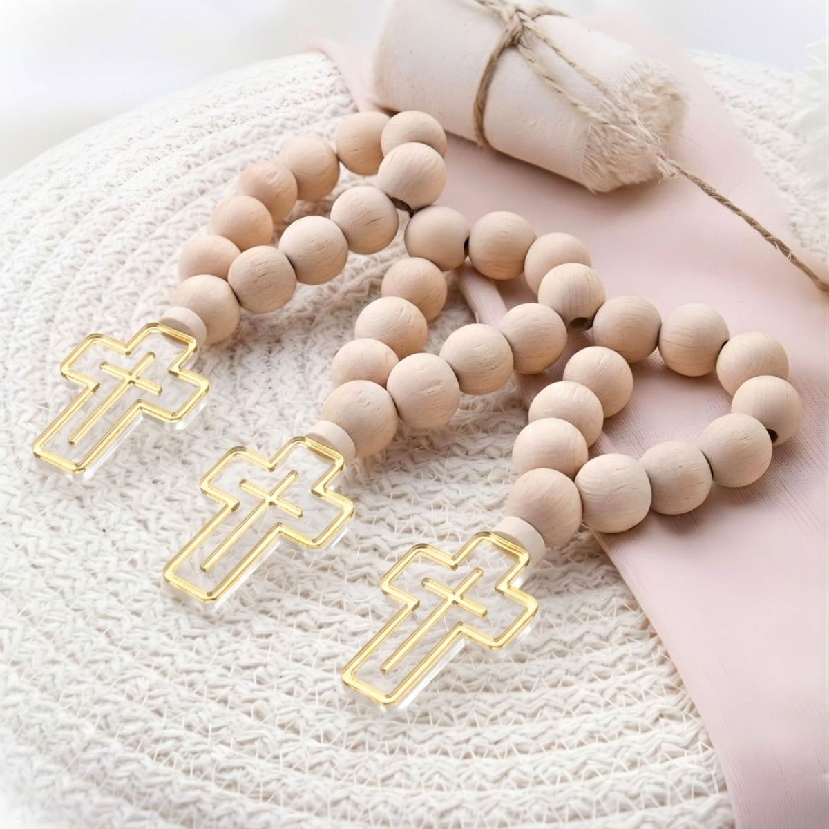 Wooden rosary with gold cross beads on a textured surface