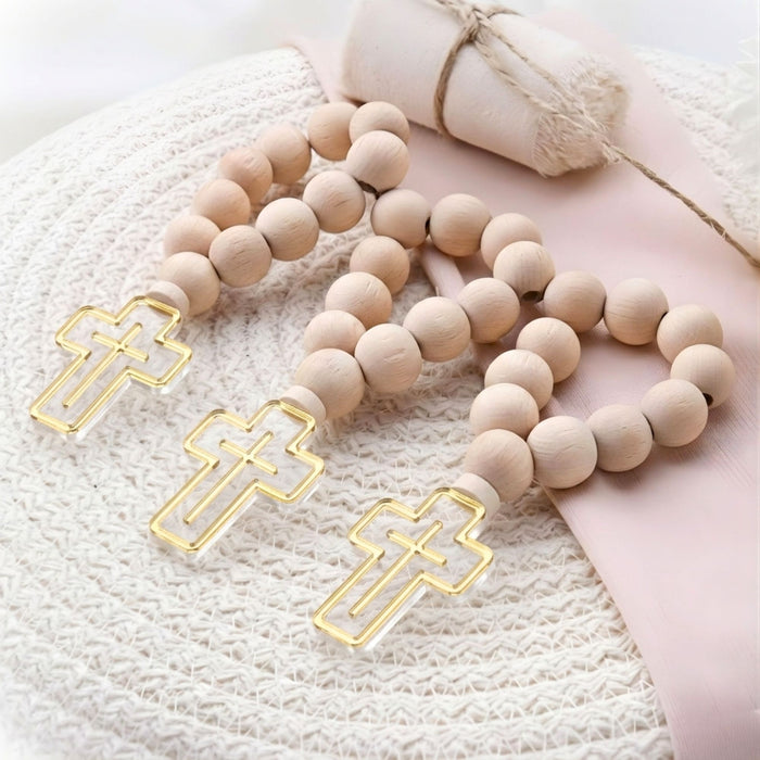 Wooden rosary with gold cross beads on a textured surface
